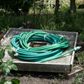 Coiled green garden hoses resting on a wooden box