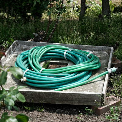 Coiled green garden hoses resting on a wooden box