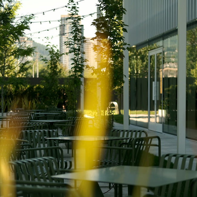 Outdoor seating area lit by overhead string lights at dusk