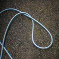 Garden hose coiled on a gravel surface