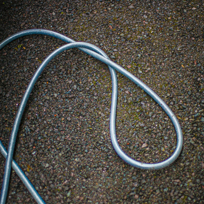 Garden hose coiled on a gravel surface
